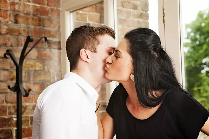 hombre y mujer se saludan con beso en la mejilla